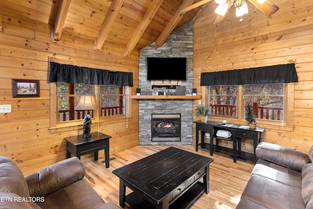 living room with wooden walls, light wood-type flooring, and lofted ceiling with beams