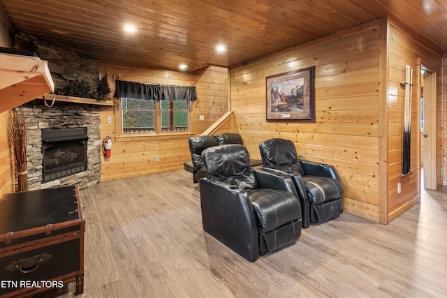 home theater room featuring hardwood / wood-style floors, a fireplace, wood walls, and wood ceiling