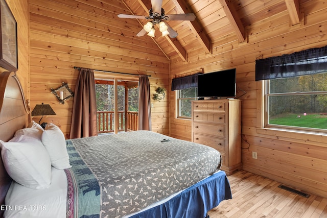 bedroom featuring access to outside, wooden walls, and light wood-type flooring