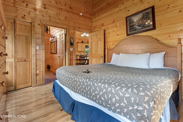 bedroom with wood-type flooring and wooden walls