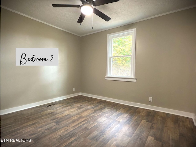 empty room featuring dark wood-type flooring, ornamental molding, a textured ceiling, and ceiling fan