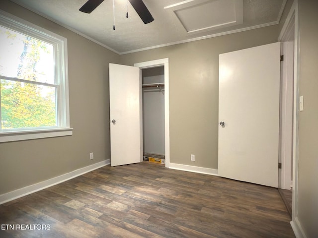 unfurnished bedroom with ornamental molding, a closet, ceiling fan, and dark hardwood / wood-style floors