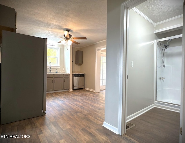 kitchen featuring ornamental molding, ceiling fan, a textured ceiling, dark wood-type flooring, and dishwasher