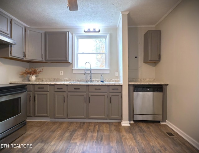 kitchen with gray cabinetry, crown molding, appliances with stainless steel finishes, dark hardwood / wood-style flooring, and sink