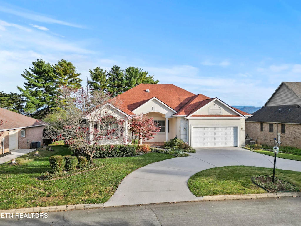 ranch-style house featuring a garage, a front yard, and central AC