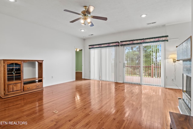 unfurnished living room featuring ceiling fan and light hardwood / wood-style flooring