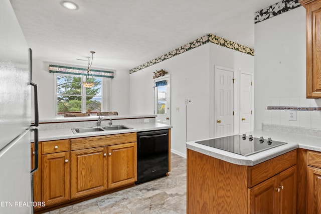 kitchen with decorative backsplash, kitchen peninsula, black appliances, sink, and decorative light fixtures