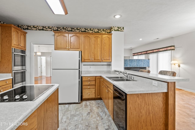 kitchen with kitchen peninsula, black appliances, and sink