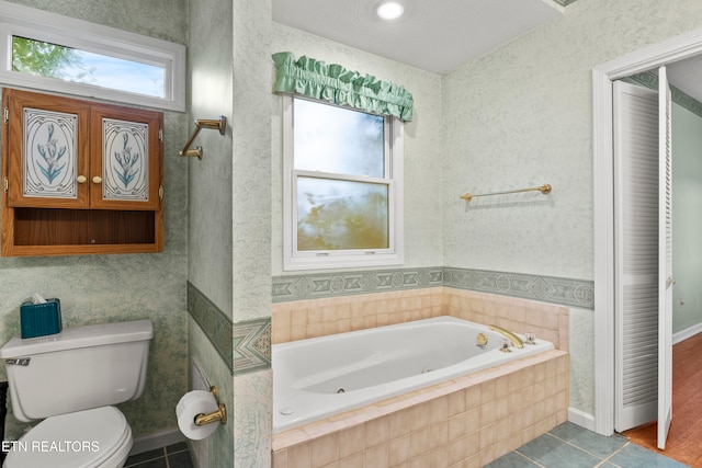 bathroom with toilet, a relaxing tiled tub, and hardwood / wood-style flooring