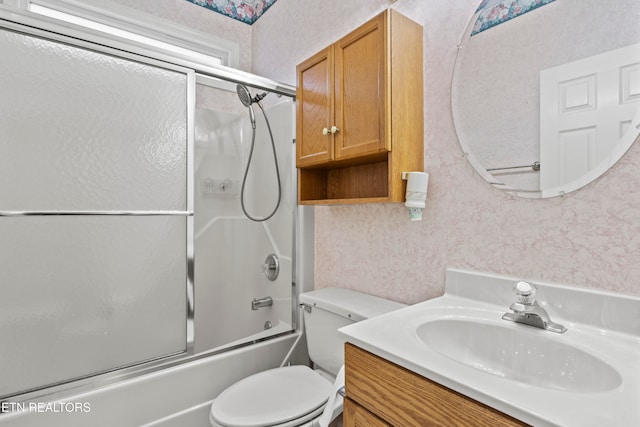 full bathroom featuring toilet, combined bath / shower with glass door, and vanity