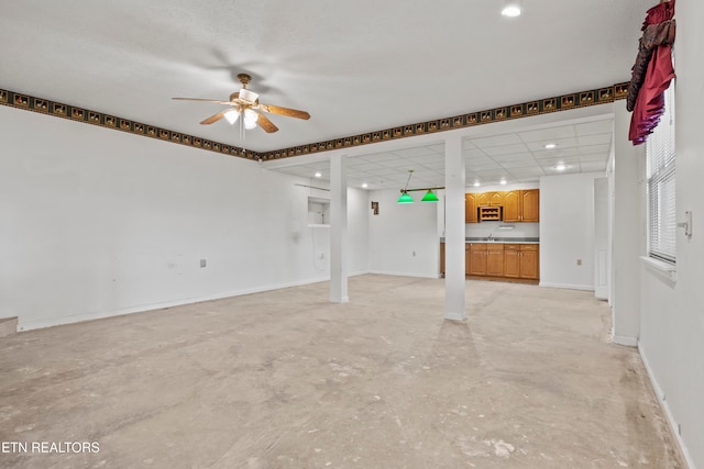 unfurnished living room with sink and ceiling fan