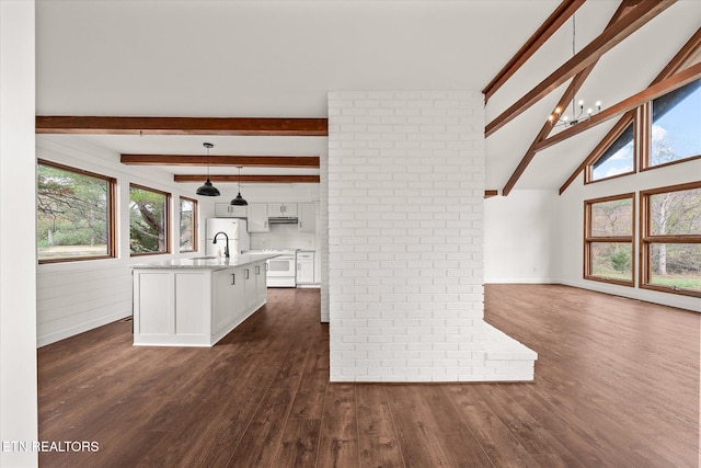 interior space featuring dark wood-type flooring, vaulted ceiling with beams, and a chandelier