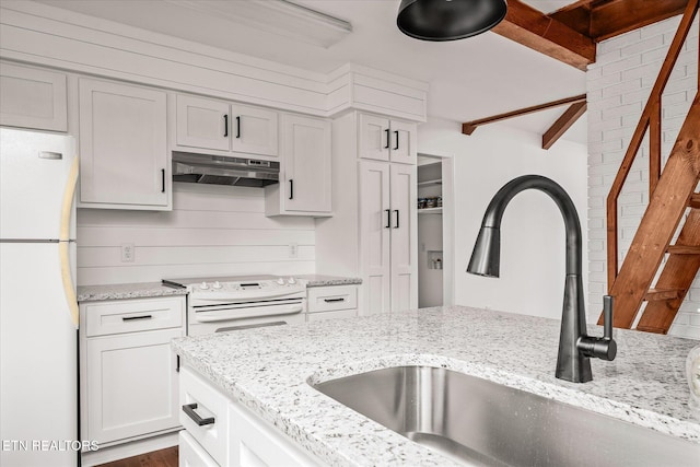 kitchen with white refrigerator, white cabinetry, light stone countertops, sink, and electric range oven