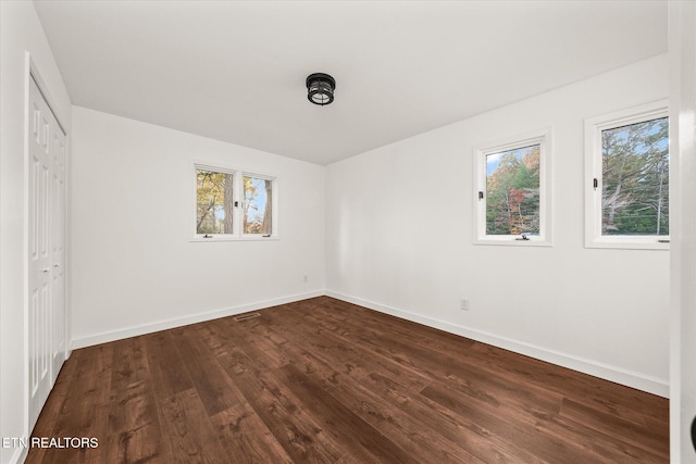 unfurnished bedroom featuring a closet and dark hardwood / wood-style floors