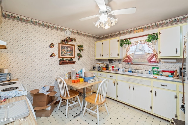 kitchen featuring white cabinetry, sink, and ceiling fan