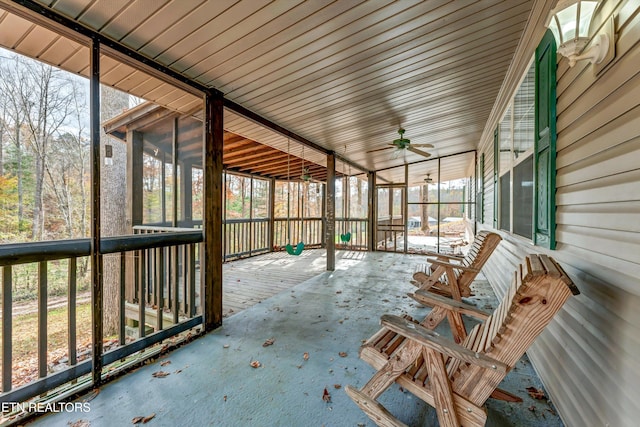 unfurnished sunroom with ceiling fan