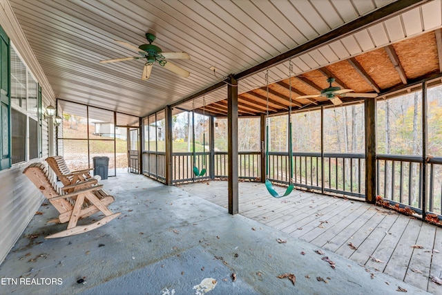 unfurnished sunroom featuring ceiling fan