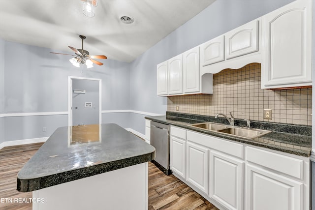 kitchen with white cabinetry, decorative backsplash, stainless steel dishwasher, and a kitchen island