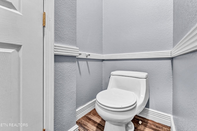 bathroom with toilet and hardwood / wood-style floors