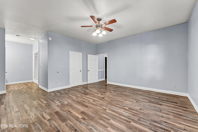 spare room with ceiling fan and dark hardwood / wood-style flooring