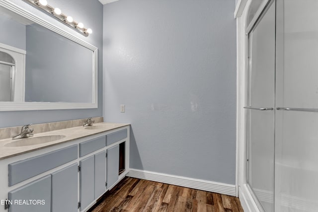 bathroom with vanity, wood-type flooring, and a shower with door