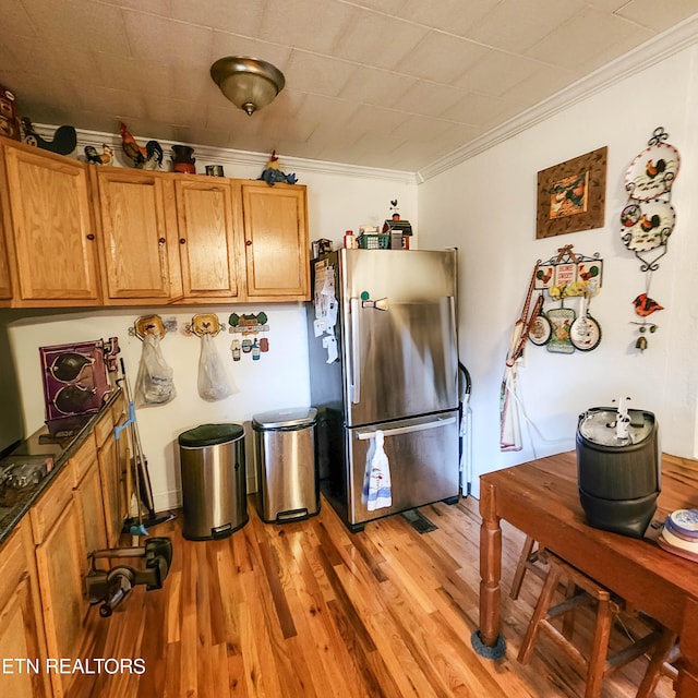 kitchen with light hardwood / wood-style floors, stainless steel fridge, and crown molding