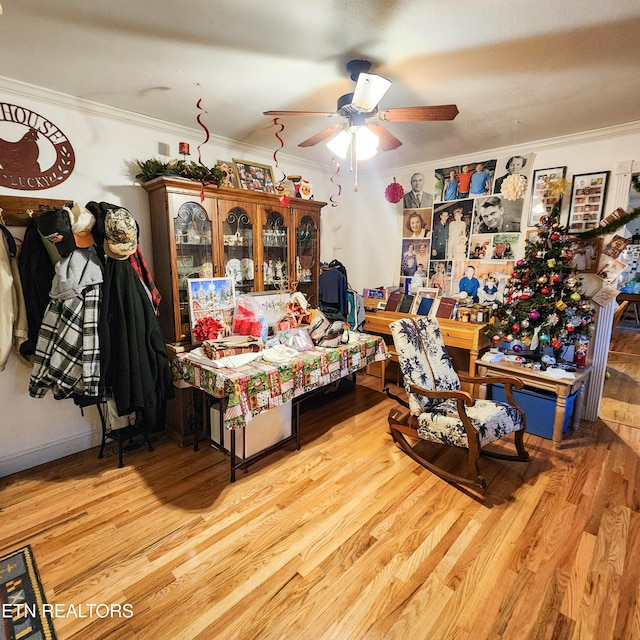 bedroom featuring light hardwood / wood-style floors, ceiling fan, and crown molding