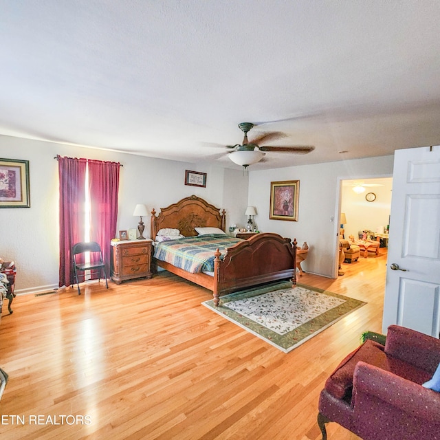 bedroom featuring hardwood / wood-style floors, ceiling fan, and a textured ceiling