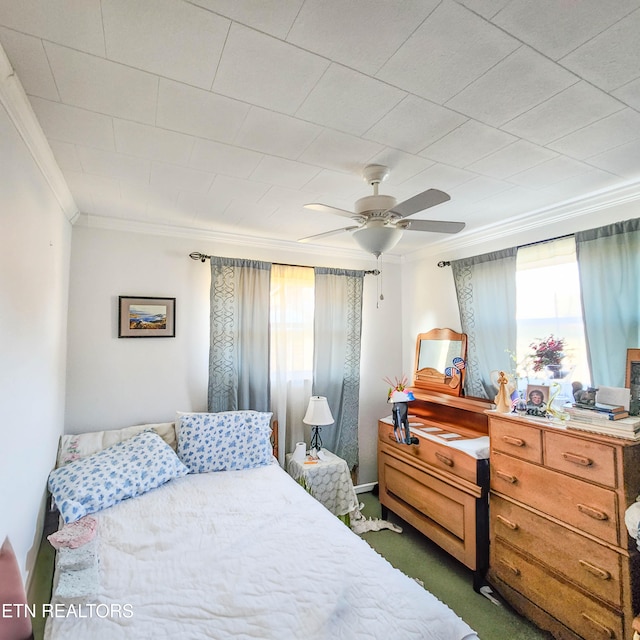 bedroom with ornamental molding, ceiling fan, and dark carpet