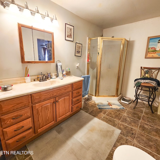 bathroom with toilet, vanity, an enclosed shower, and tile patterned flooring