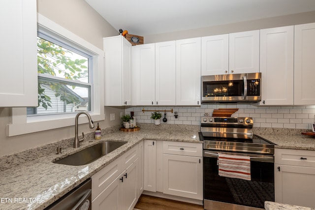 kitchen with a healthy amount of sunlight, sink, appliances with stainless steel finishes, and white cabinetry