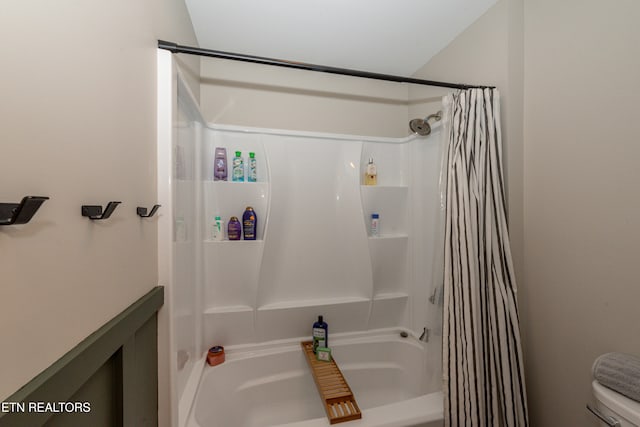 bathroom with toilet and shower / bath combo with shower curtain