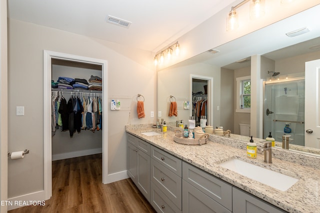 bathroom featuring a shower with door, vanity, and hardwood / wood-style flooring