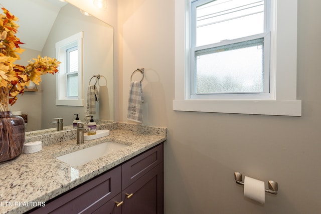 bathroom featuring vanity and lofted ceiling