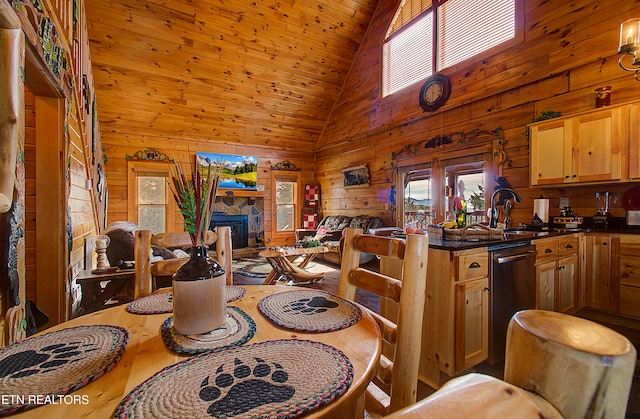 dining room featuring high vaulted ceiling, sink, a fireplace, and wooden walls