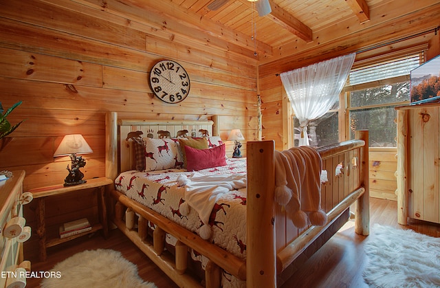 bedroom with beamed ceiling, hardwood / wood-style flooring, wooden ceiling, and wood walls