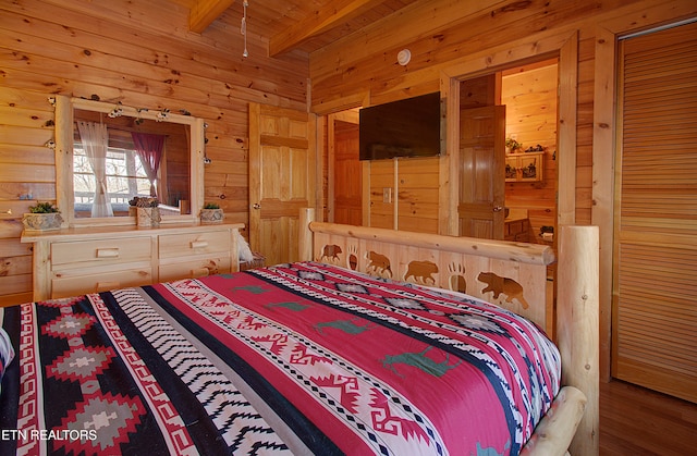 bedroom with wood walls and beam ceiling