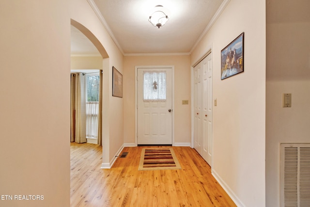 doorway featuring crown molding and light hardwood / wood-style flooring