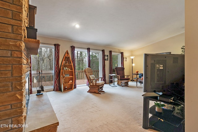 living room with a fireplace, carpet floors, and lofted ceiling