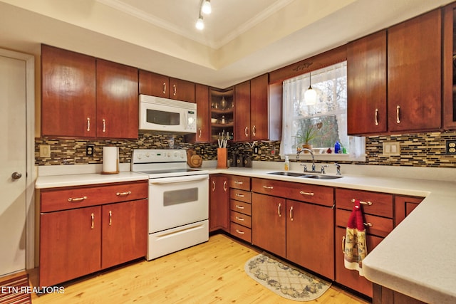 kitchen with sink, crown molding, decorative light fixtures, white appliances, and light wood-type flooring