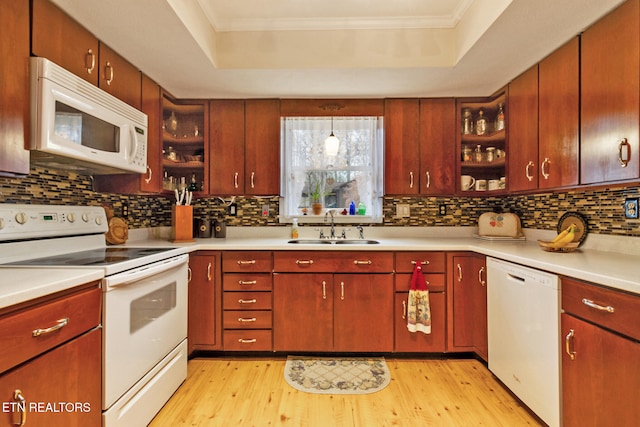 kitchen featuring sink, pendant lighting, white appliances, and light hardwood / wood-style flooring