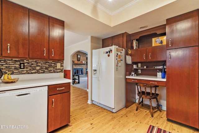 kitchen with decorative backsplash, light wood-type flooring, white appliances, and crown molding