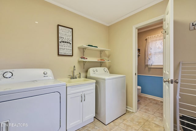 washroom featuring washer and clothes dryer, cabinets, sink, ornamental molding, and light tile patterned floors