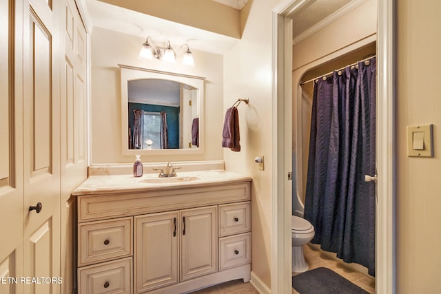 bathroom with tile patterned floors, vanity, toilet, and ornamental molding