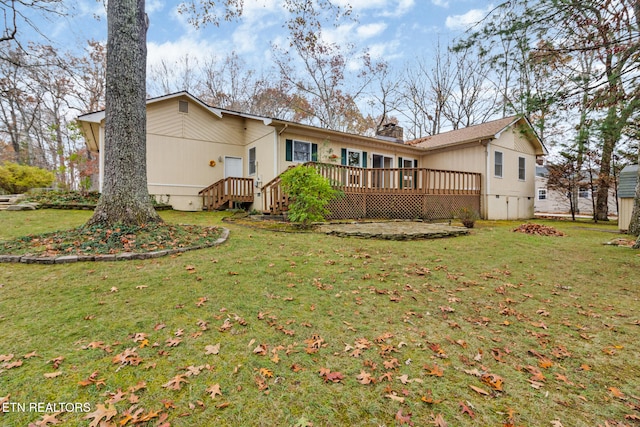 rear view of house with a lawn and a wooden deck