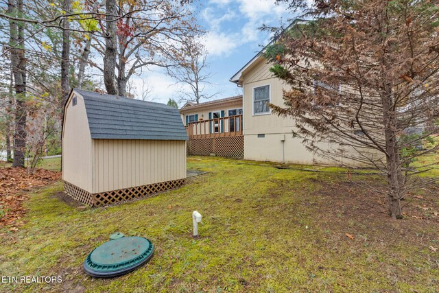 view of yard with a wooden deck and a shed