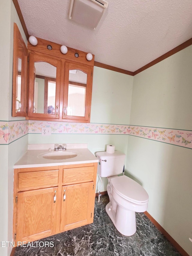 bathroom with vanity, toilet, crown molding, and a textured ceiling