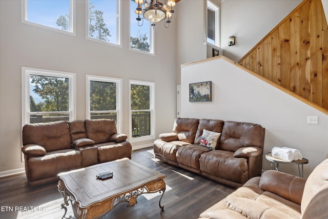 living room featuring a notable chandelier, dark hardwood / wood-style flooring, and a high ceiling