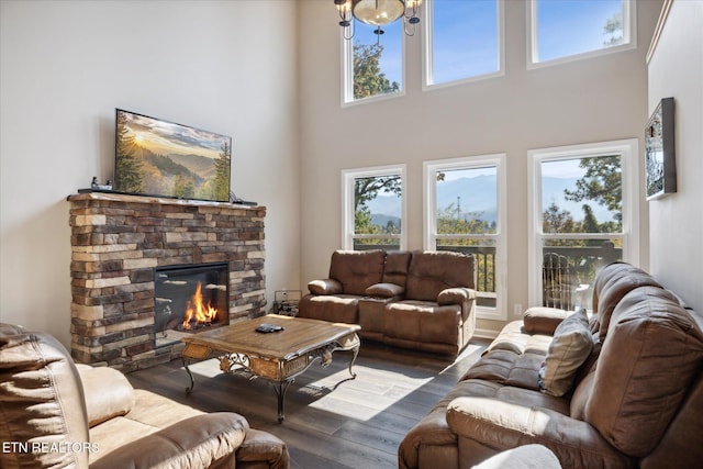 living room featuring hardwood / wood-style flooring, a high ceiling, and a fireplace