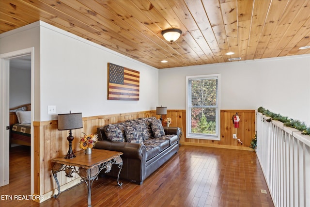 living room with ornamental molding, wood-type flooring, wooden ceiling, and wooden walls